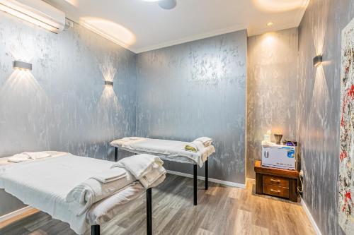 a hospital room with two beds and a tv at Hotel House in Rishon LeẔiyyon