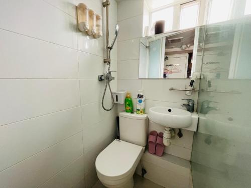 a small bathroom with a toilet and a sink at 香港铃木旅馆 in Hong Kong