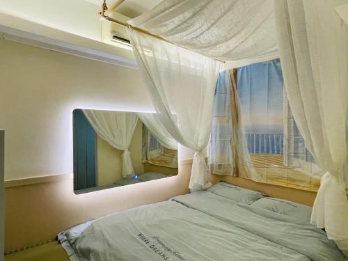 a bedroom with a bed and a window with curtains at 香港铃木旅馆 in Hong Kong