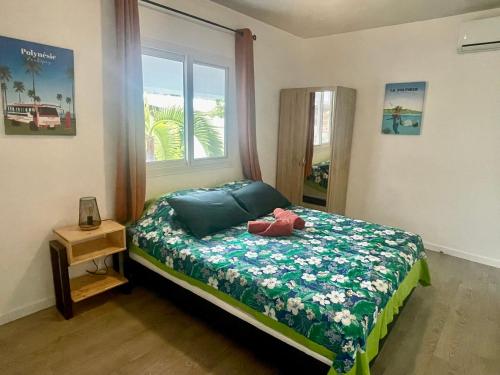 un dormitorio con un osito de peluche sentado en una cama en Vanakea Beach House en Punaauia