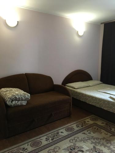 a living room with a couch and a bed at Номер та Паркінг- Світло Є in Chernivtsi