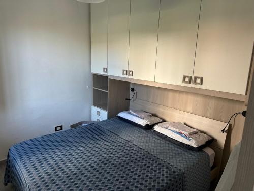 - une chambre avec un lit et des armoires blanches dans l'établissement Riva del Golfo Casa Vacanze, à Campora San Giovanni