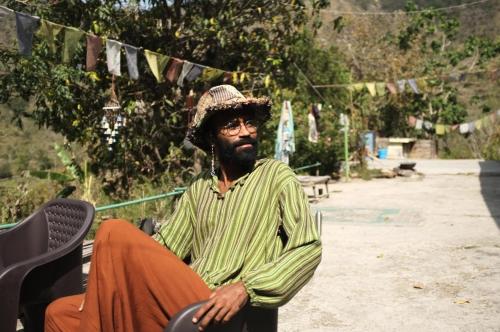 a man wearing a hat sitting on a chair at Clan Boho in Rishīkesh