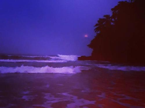 a beach at night with waves in the ocean at Talalla Wonder View in Talalla