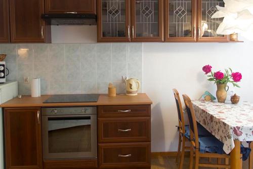 a kitchen with a counter and a table with a stove at Domek w Narewce in Narewka