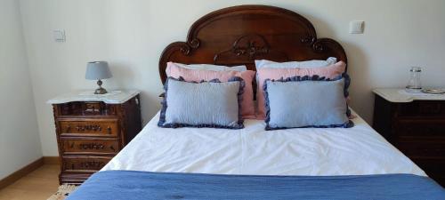 a bed with pink and blue pillows on it at Grandma´s House 