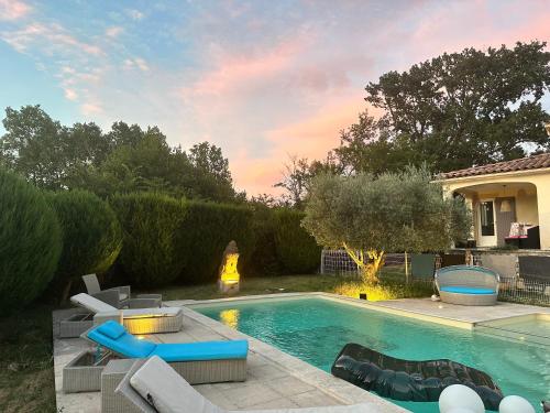 une cour arrière avec une piscine et une maison dans l'établissement Villa Superbe Vue, à La Bruguière