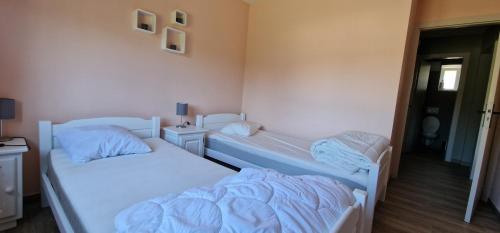 Gîte Les counehets avec local séparé في كورنيمونت: سريرين في غرفة صغيرة ذات أغطية زرقاء