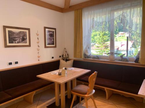 a dining room with a table and a window at B&B MARINA contacless check in in Santa Cristina Gherdëina