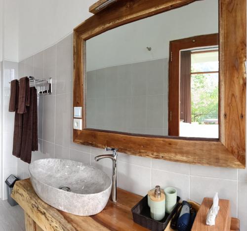 a bathroom with a stone sink and a mirror at Gumi Ayu EcoStay in Munduk