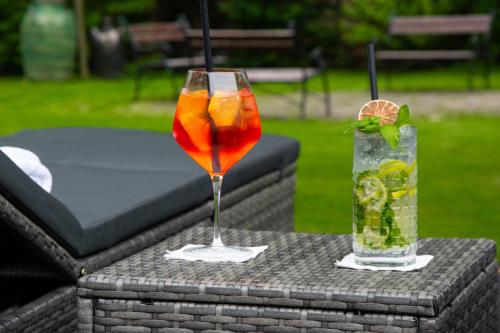 une boisson assise sur une table à côté d'un verre dans l'établissement Hotel Czinege & Étterem, à Kóka