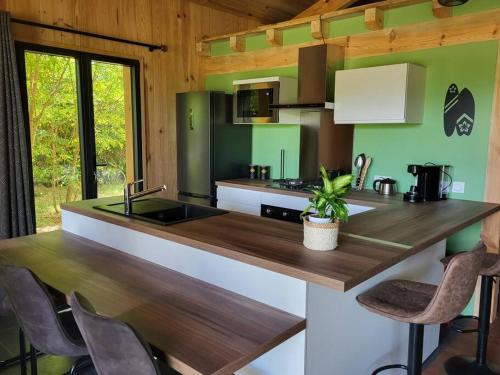 - une cuisine avec des murs verts et un comptoir en bois dans l'établissement La cabane d' Esting, à Mimizan