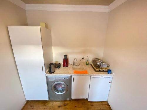 a small kitchen with a washing machine and a refrigerator at Reds Bungalow in Didim