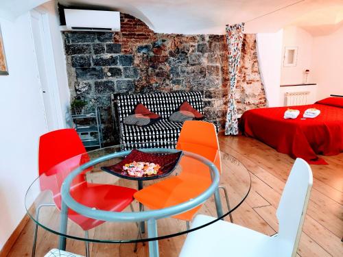 - un salon avec une table en verre et des chaises rouges dans l'établissement Le Grazie Maisons Genova, à Gênes