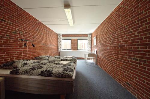 a bedroom with a bed against a brick wall at STAY and SLEEP Grindsted - Billund in Grindsted