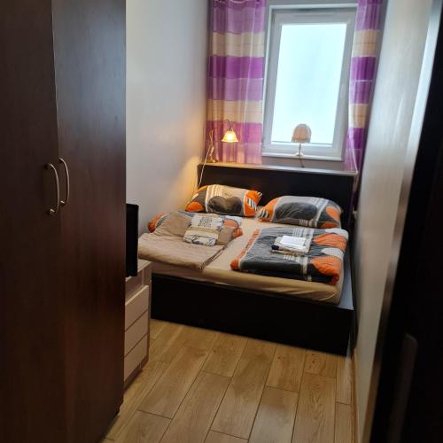una piccola camera con letto e finestra di Apartament Międzyzdroje 4 osoby - 100 m od morza a Międzyzdroje