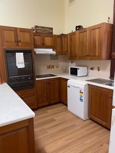 una cocina con armarios de madera y electrodomésticos blancos en 122 on Charlotte, en Cooktown