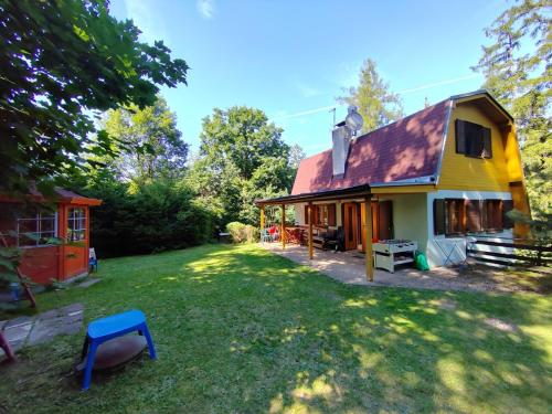 a yellow house with a red roof and a yard at Holiday House Vranov Dam in Oslnovice