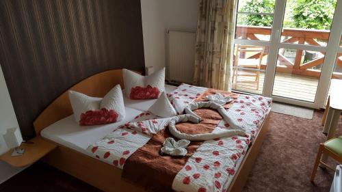Una cama con un corazón hecho de almohadas en Pension Rüdigsdorfer Schweiz, en Nordhausen