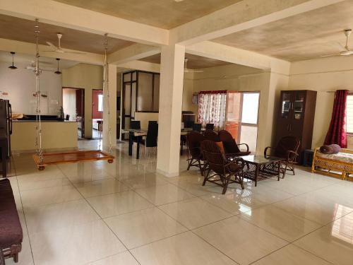 a living room with chairs and a table and a dining room at Villa with valley view Panhala in Panhāla