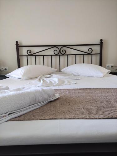 a bed with white sheets and pillows on it at Paradise Garden Paros in Piso Livadi