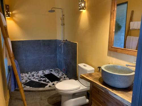 a bathroom with a tub and a toilet and a sink at Eco Lagoon in Phu Quoc