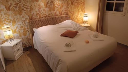 a bedroom with a white bed with two towels on it at Fermette Landaise près de l'Océan et du lac marin in Vieux-Boucau-les-Bains
