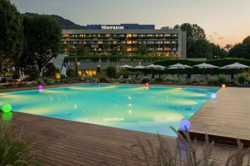 une grande piscine en face d'un hôtel dans l'établissement Sheraton Lake Como Hotel, à Côme