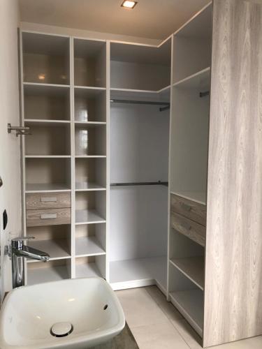 勒拉芒丹的住宿－L'Escapade la Villa de vos prochaines vacances，浴室配有带水槽的白色衣柜