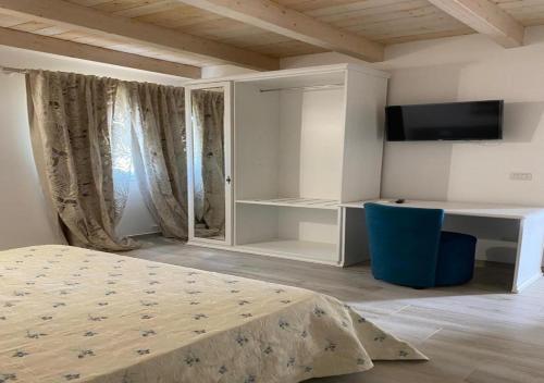 Schlafzimmer mit einem Bett, einem Schreibtisch und einem TV in der Unterkunft Camere Marisol in Porto Cesareo