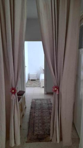 a hallway with curtains in a room with a bed at Appartment Corniche in Sousse