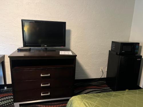 - une télévision installée au-dessus d'une commode avec un lit dans l'établissement Applegate Inn, à Cleveland