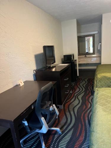 a hotel room with a desk and a chair at Applegate Inn in Cleveland