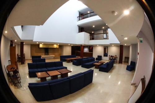 a view of a hospital lobby with blue chairs and tables at Hotel dos Cavaleiros in Torres Novas