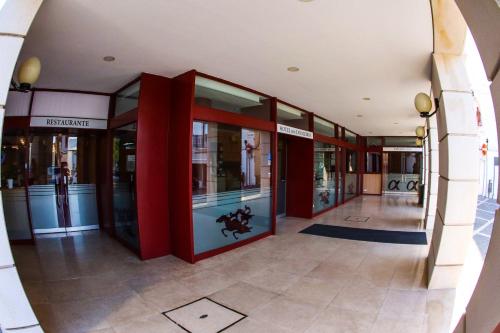 une entrée à un bâtiment avec des colonnes rouges et des fenêtres dans l'établissement Hotel dos Cavaleiros, à Torres Novas