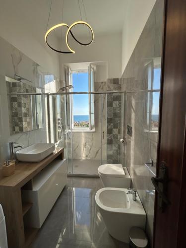 een badkamer met 2 wastafels, een toilet en een raam bij Maison Nisco in Ercolano