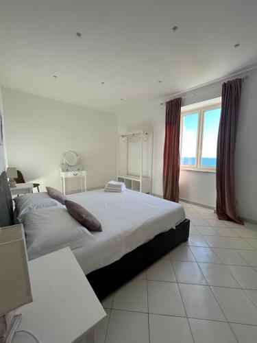 een slaapkamer met een groot bed en een groot raam bij Maison Nisco in Ercolano