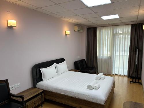 een slaapkamer met een bed met twee handdoeken erop bij Hotel Four Season in Tbilisi City