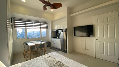 a bedroom with a kitchen with a table and a refrigerator at Calyx Residences 18i in Cebu City