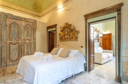 una camera da letto con un letto bianco con due scarpe bianche di Casa Matilde a Montepulciano