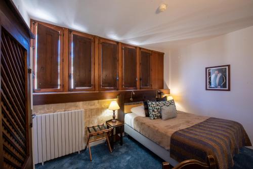 a bedroom with a bed and wooden cabinets at Chateau des Ducs de Joueuse, BW Signature Collection in Couiza