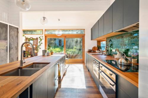 a kitchen with a sink and a large window at 'Questa' Heritage Cottage in Barnes Bay