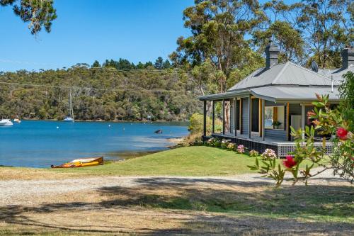 a house on the shore of a body of water at 'Questa' Heritage Cottage in Barnes Bay