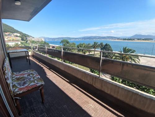 een stoel op een balkon met uitzicht op de oceaan bij Espectaculares Vistas in Santoña