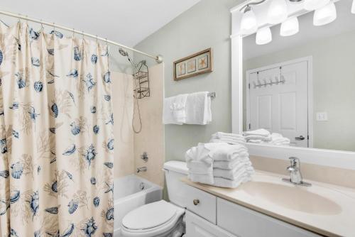 a bathroom with a sink and a toilet and a shower at Tidewater 314 NEW in Panama City Beach