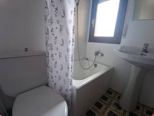een badkamer met een toilet, een wastafel en een douchegordijn bij Espectaculares Vistas in Santoña