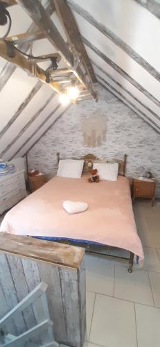 ein Schlafzimmer mit einem Bett im Dachgeschoss in der Unterkunft LA P'TITE MAISON in Charleroi