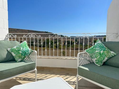 a balcony with two chairs and a view of the ocean at Dar Sara Gozo in Victoria