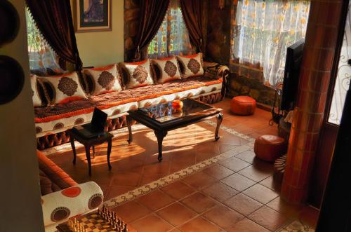 ein Wohnzimmer mit einem Sofa und einem Tisch in der Unterkunft Villa Authentique avec Vue Panoramique à 3 km de Chefchaouen in Chefchaouen