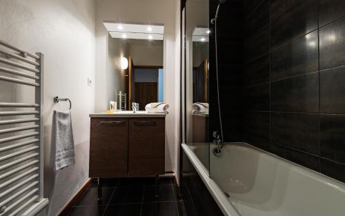 a bathroom with a bath tub and a sink at Lagrange Vacances Le Clos Saint Hilaire in Saint-Lary-Soulan
